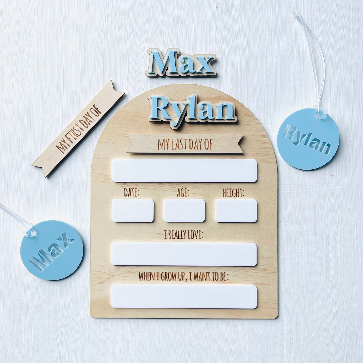 Wooden board with cutout letters spelling 'Rylan' and various text boxes on a light background