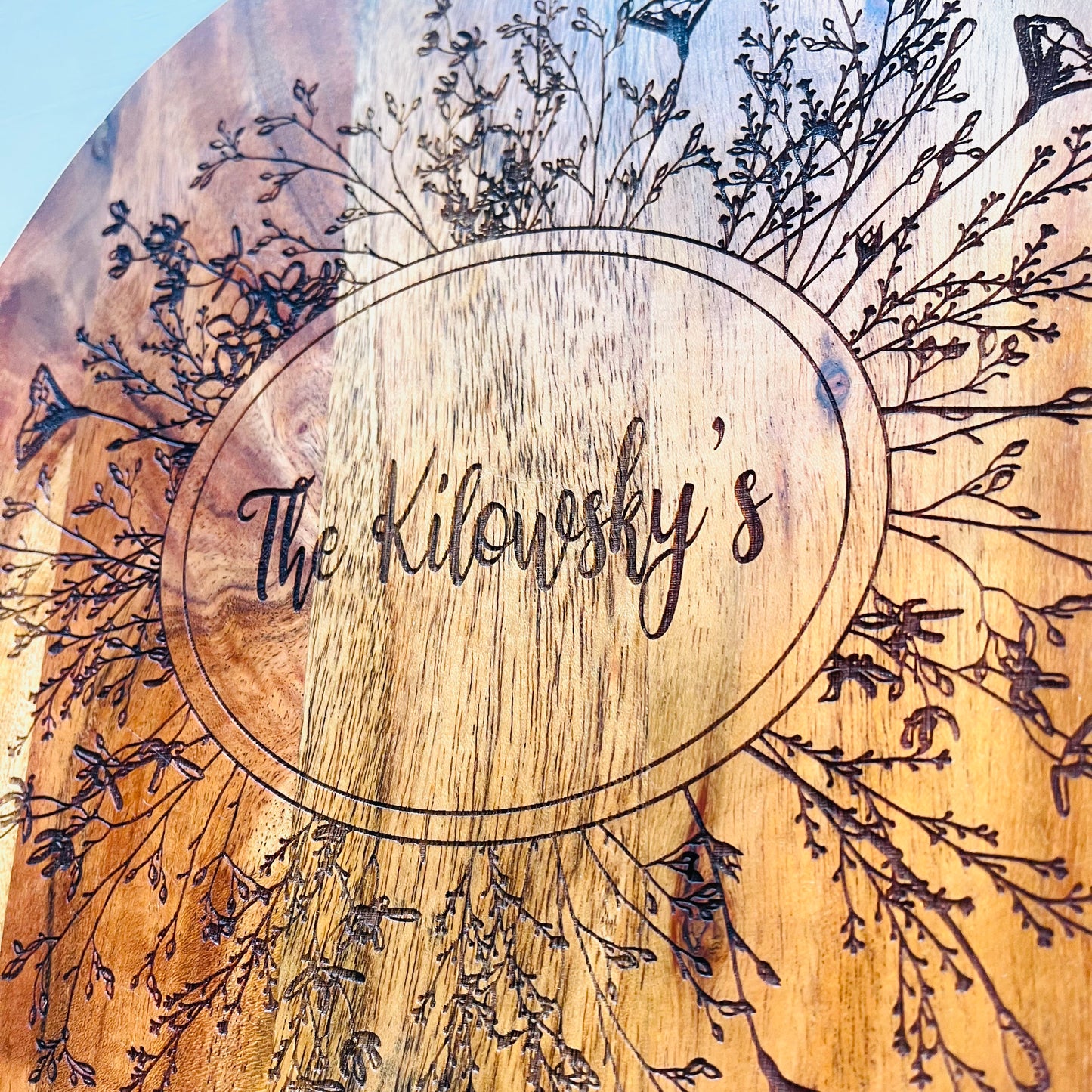 A handcrafted wooden grazing board with engraved wildflowers, personalized with your name or family surname. Perfect for home cooks, weddings, or housewarming gifts