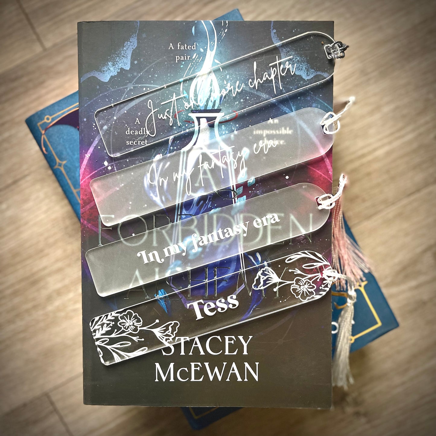 Book with transparent bookmarks featuring text and a tassel on a wooden surface