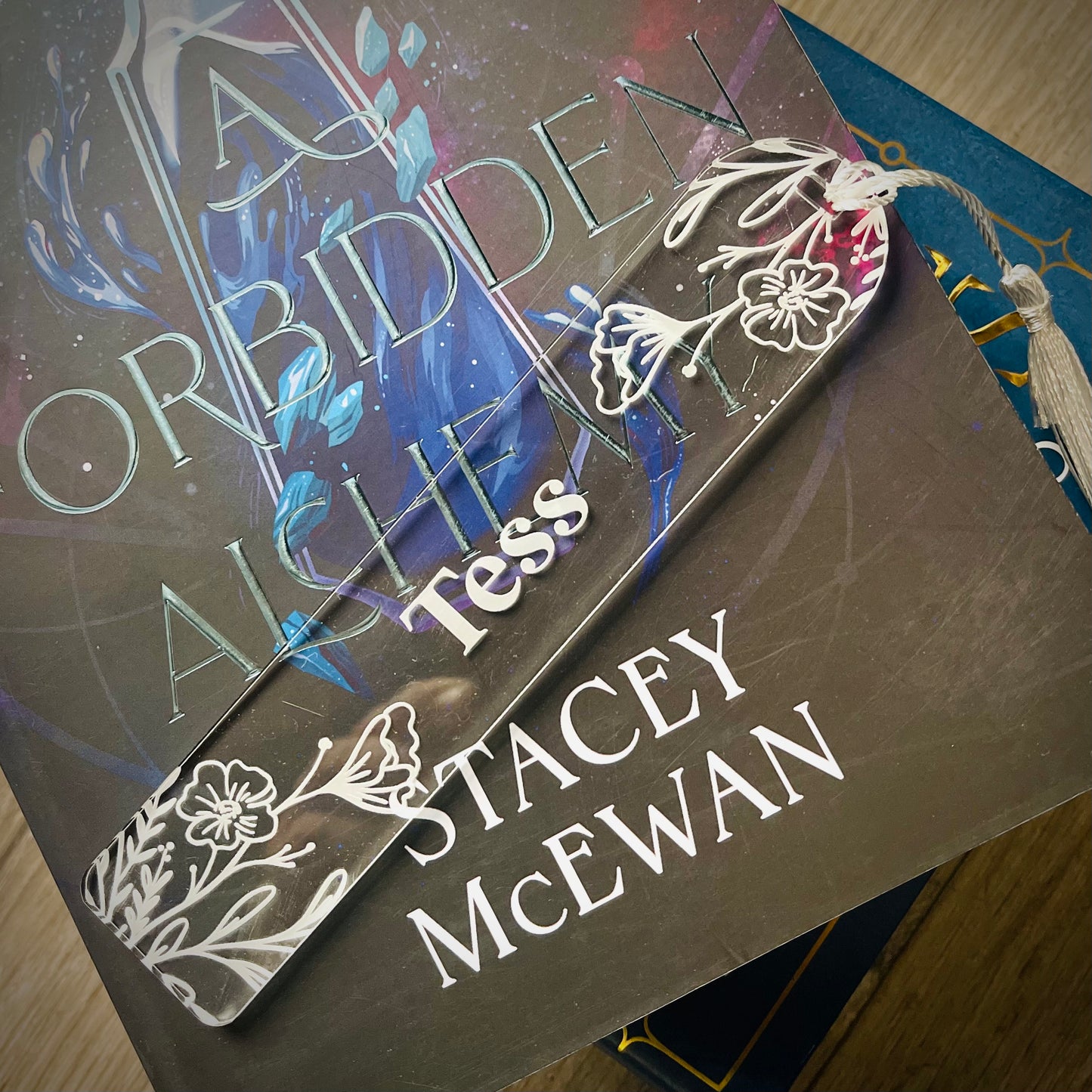 Book cover of 'A Forbidden Alchemy' by Tess Stacey McEwan with decorative elements.